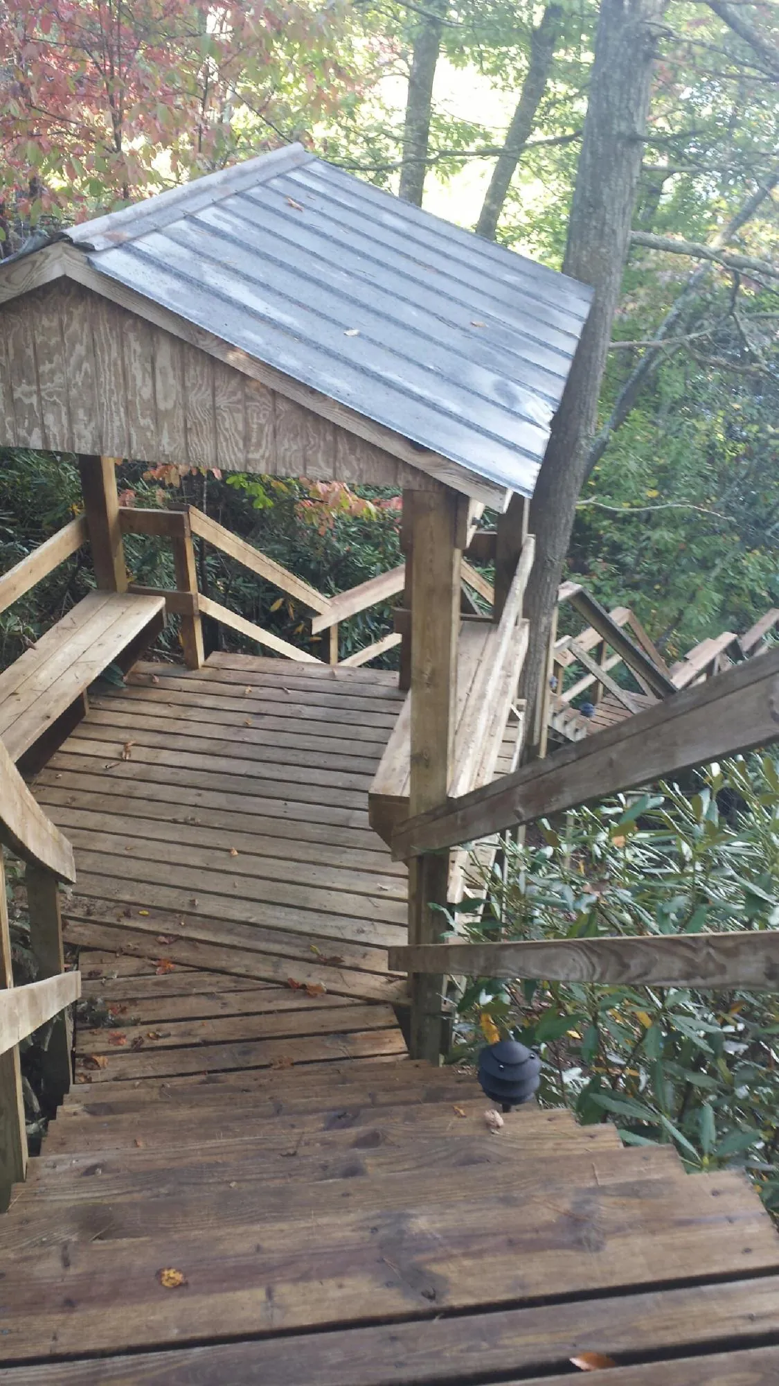 Metal roofed shelter over wooden steps on a wooded walkway — Skylight Repair & Installation work by our crew in Whitinsville
