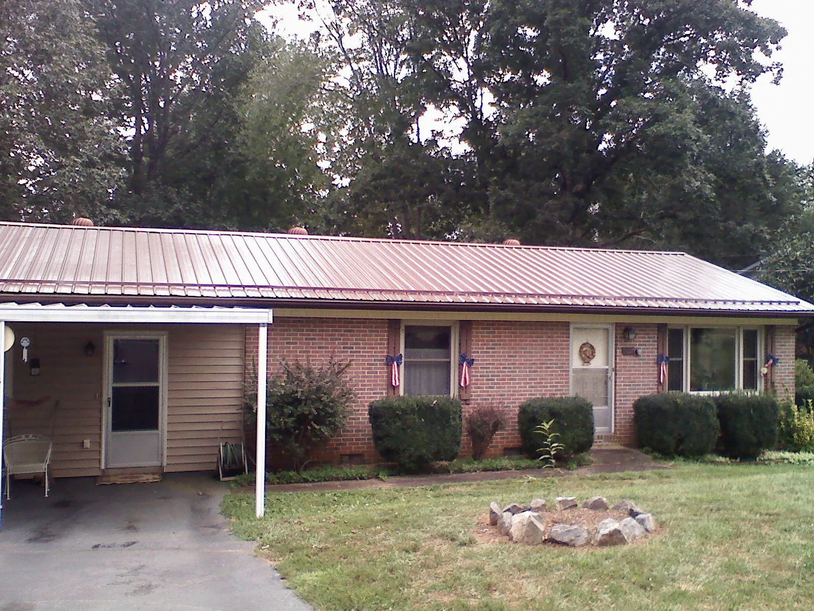 Bronze metal roof and carport on a brick ranch home — Roof Repair work by our crew in Whitinsville
